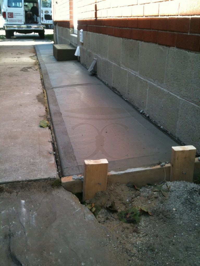 New concrete slab with formwork beside the building wall