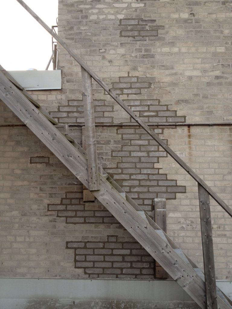 Same wall with new bricks filled in behind the staircase