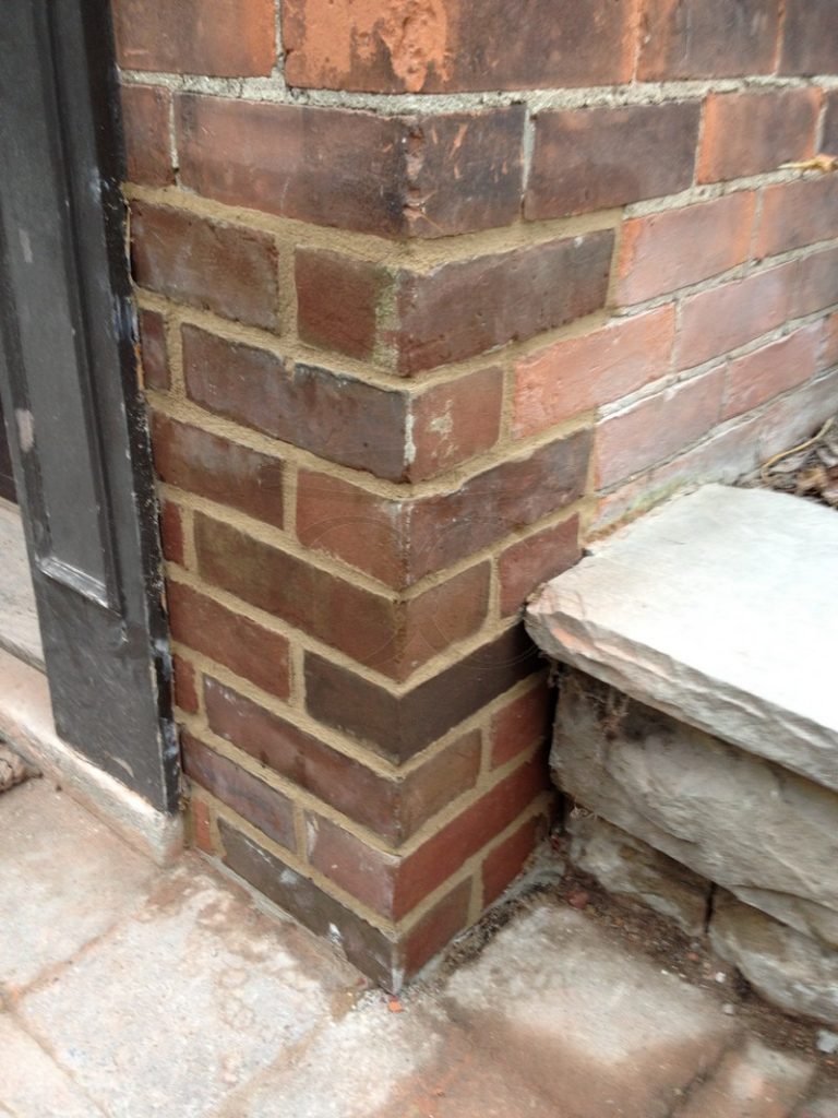 Rebuilt brick corner beside the stone step