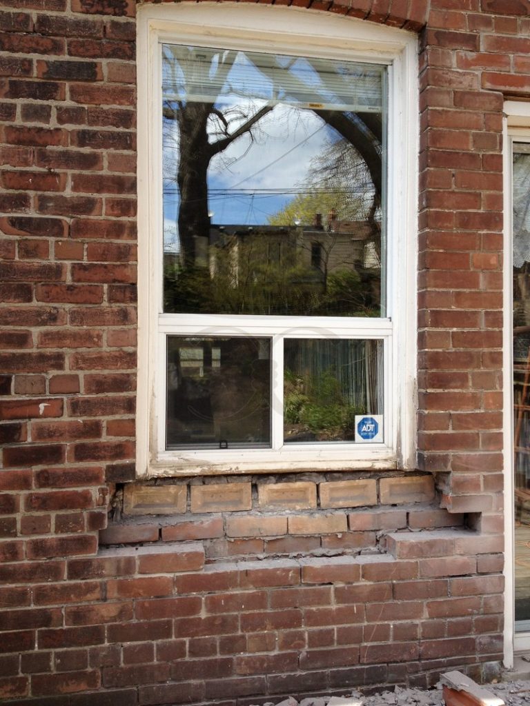 Brick below a window with a damaged section under the sill