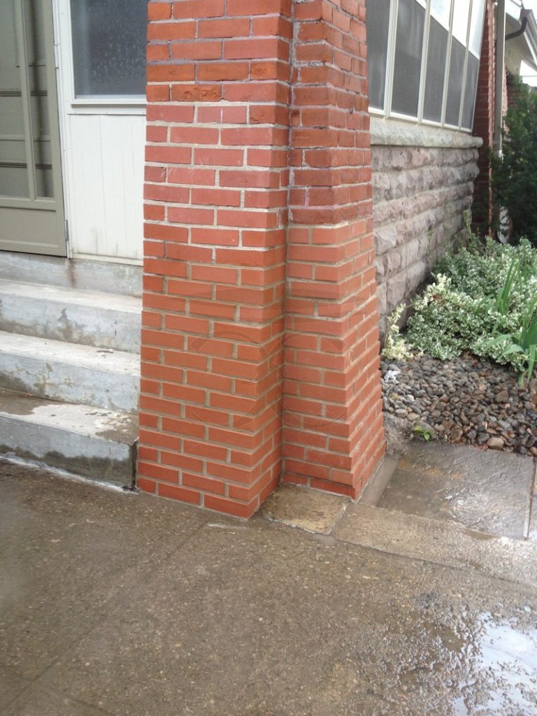 Rebuilt red brick pillar beside the steps