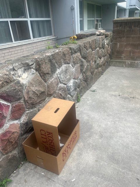 Fieldstone retaining wall beside a concrete patio and house